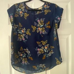 Size large. Navy blue background with floral accents.